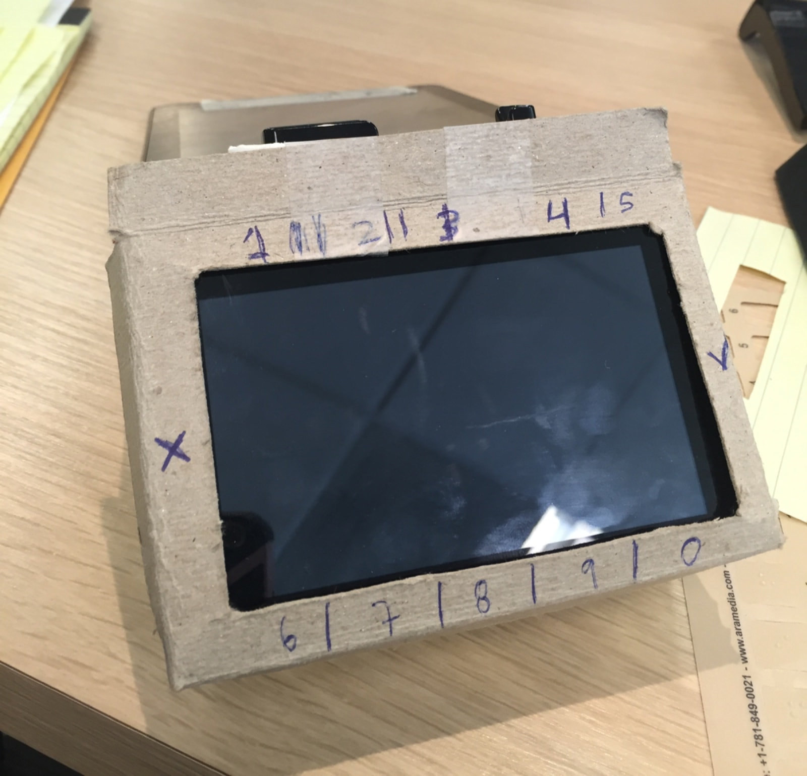 A cardboard frame taped around the terminal, numbers written on it in marker