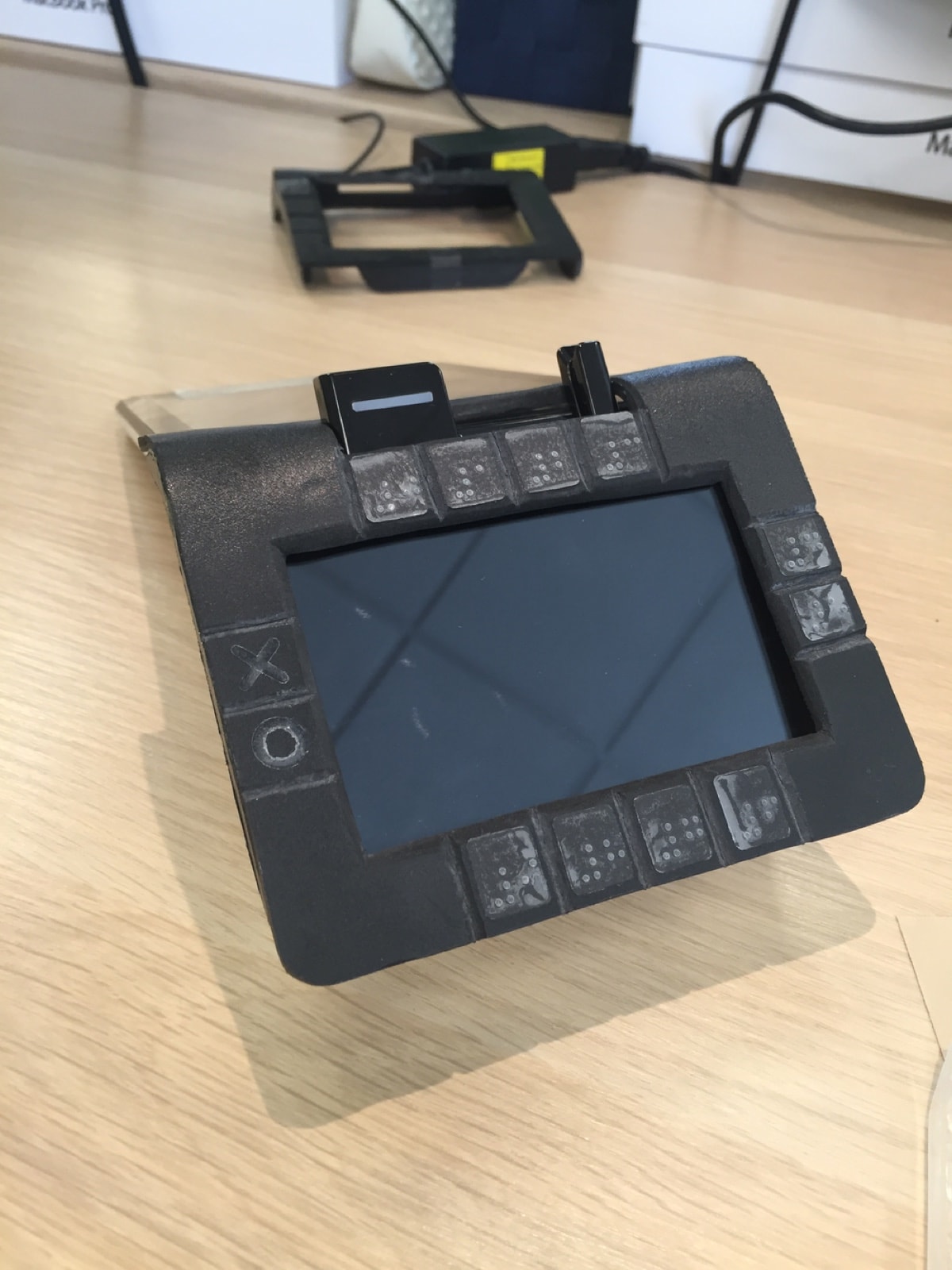 A PVC foam frame fitted to the terminal, with raised Braille labels