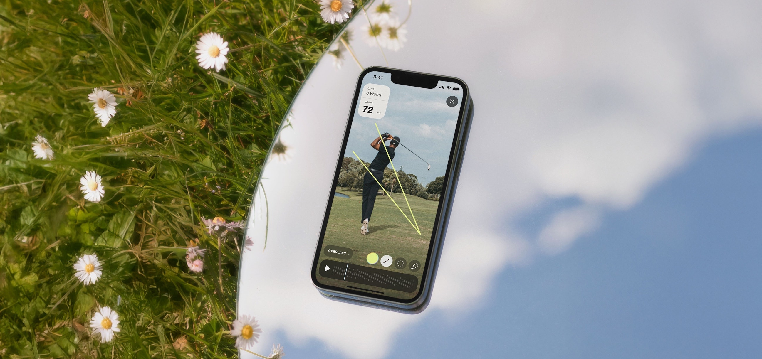 Totality Golf running on a phone resting on a mirror in grass and daisies